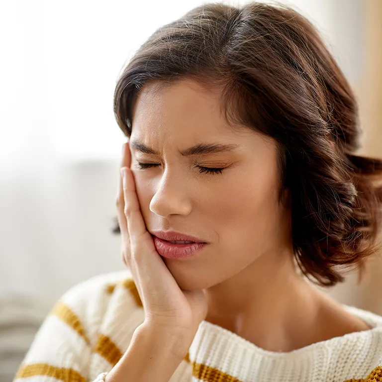 Image of a woman in pain holding her jaw