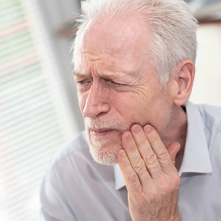 Image of a woman in pain holding her jaw