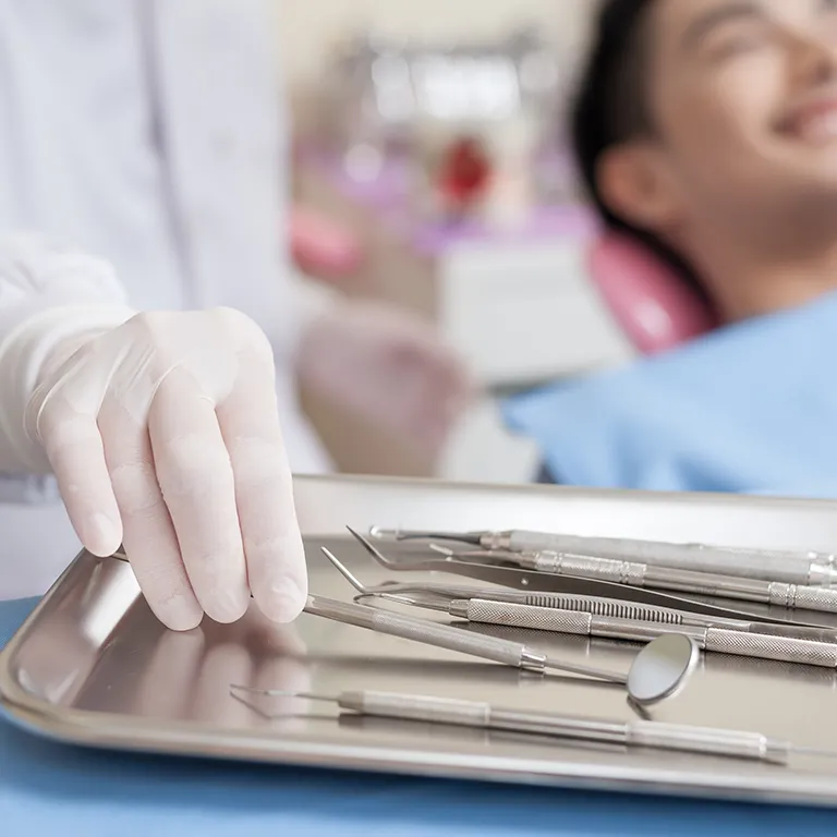 Image of a dentist grabbing a tool