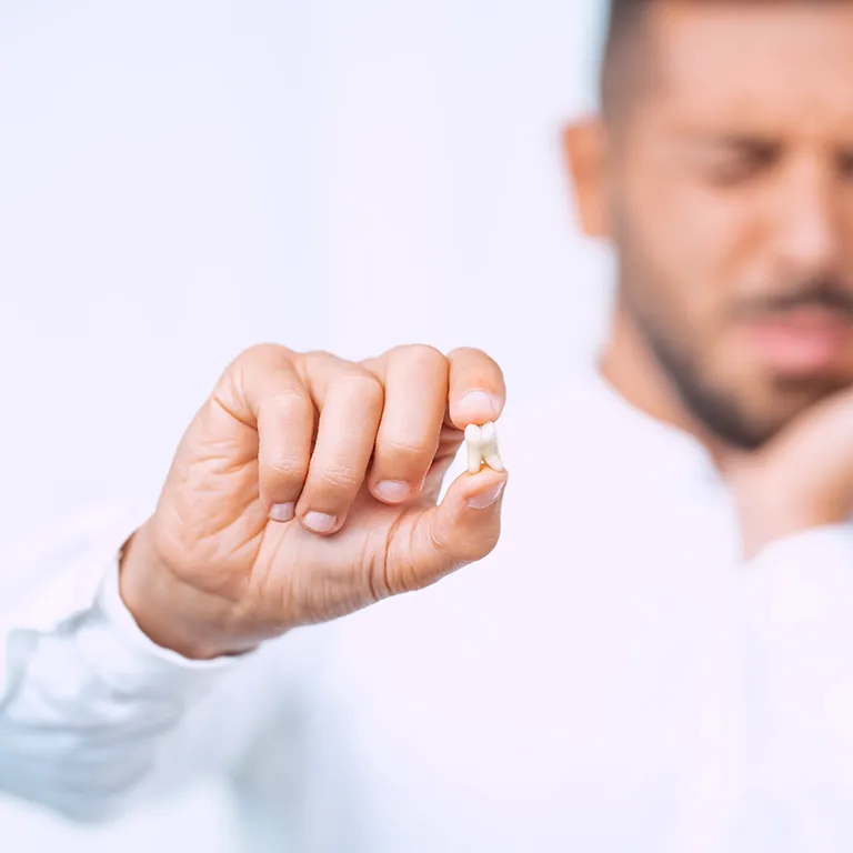 Image of a man holding a wisdom tooth