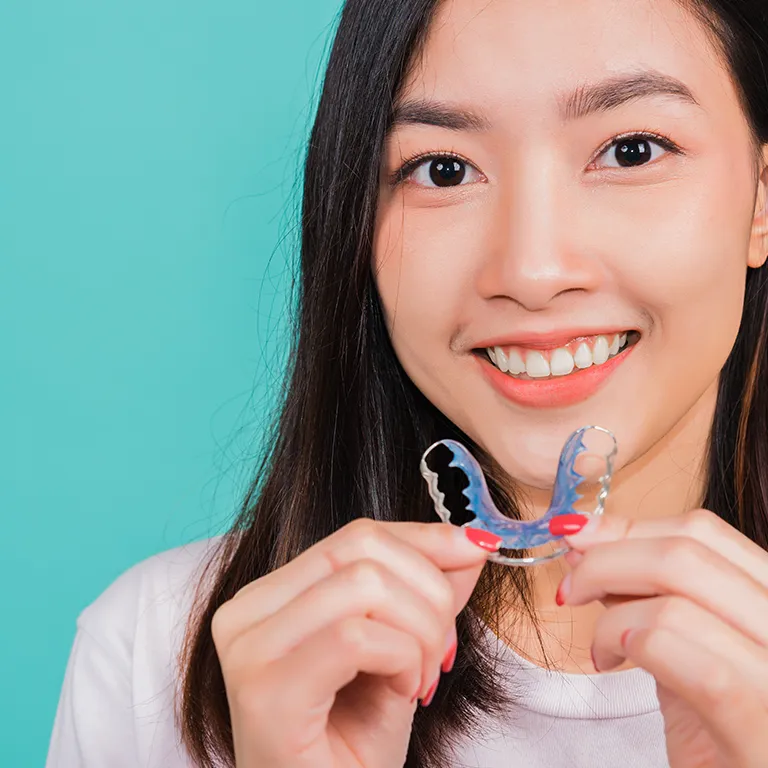 Image of a woman holding a retainer