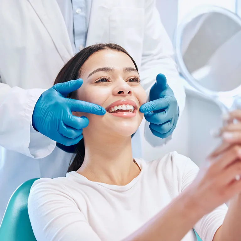 Image of a dentist pointing at a patients smile