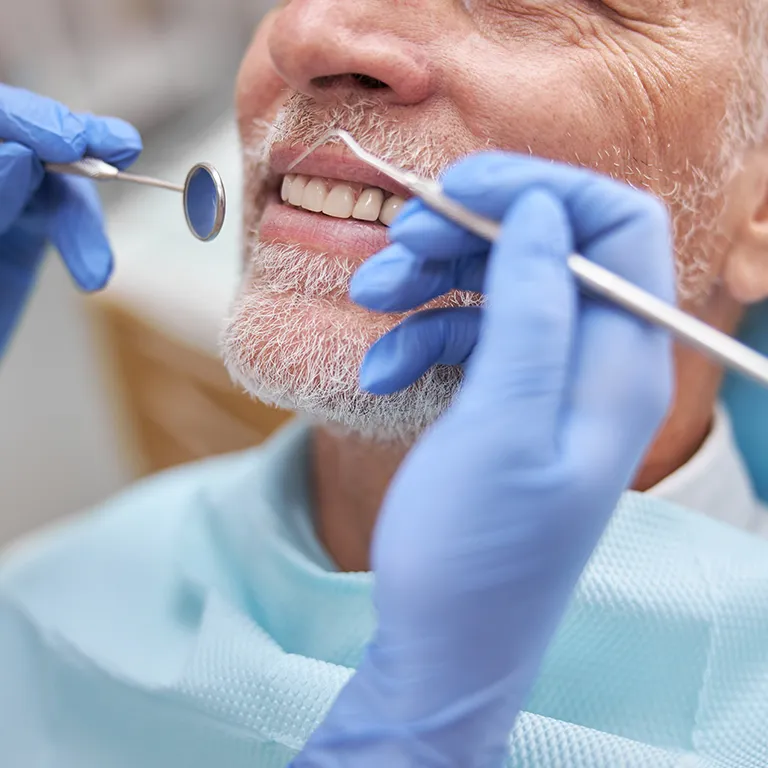 Image of a dentist cleaning a mans teeth