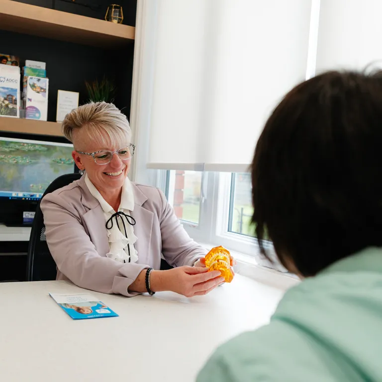 Image of a woman at a desk meeting with someone