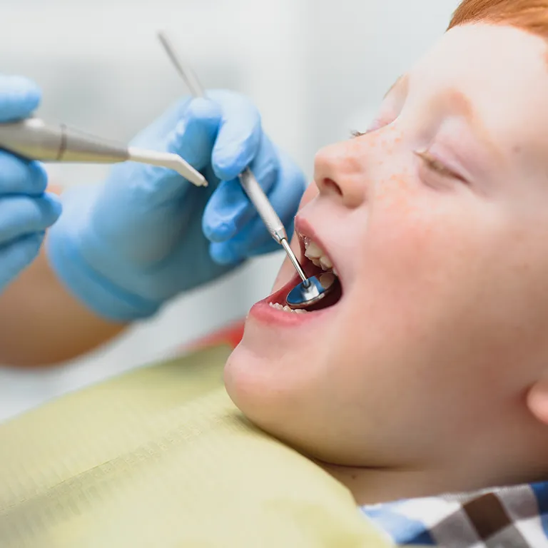 Image of a child having their teeth examined